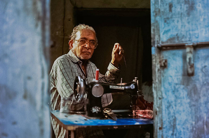 Thợ may Abdul Hakim, 75 tuổi, đang làm việc trong tiệm may của ông.
