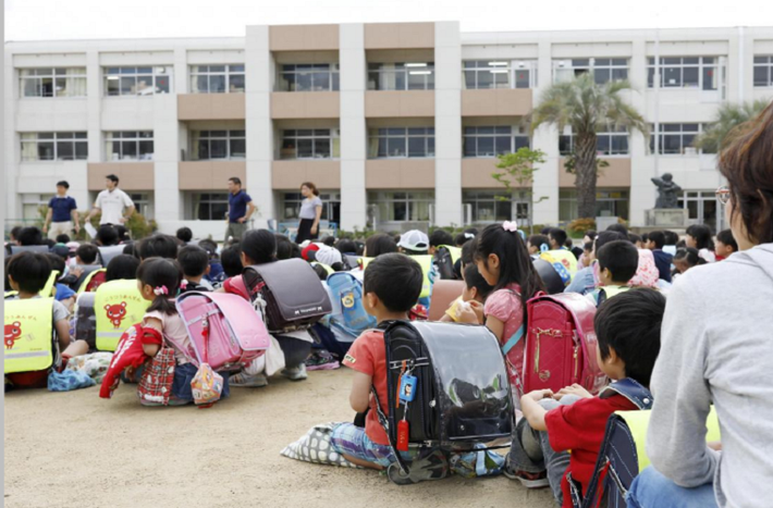 Các em học sinh được sơ tán khỏi trường học sau trận động đất tại trường tiểu học Ikeda, tỉnh Osaka, ngày 18/6. Ảnh: Reuters.