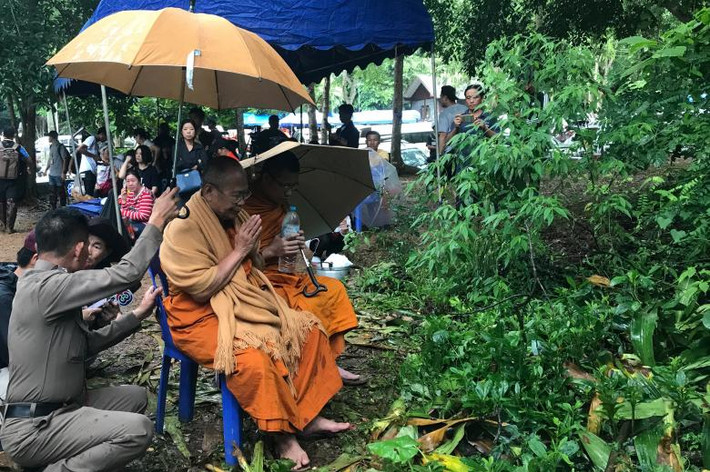Các nhà sư cầu nguyện bên ngoài hang động.