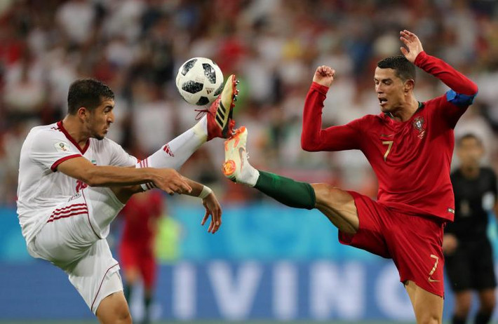 Pha tranh chấp bóng giữa cầu thủ Majid Hosseini của Iran với Cristiano Ronaldo của Bồ Đào Nha.