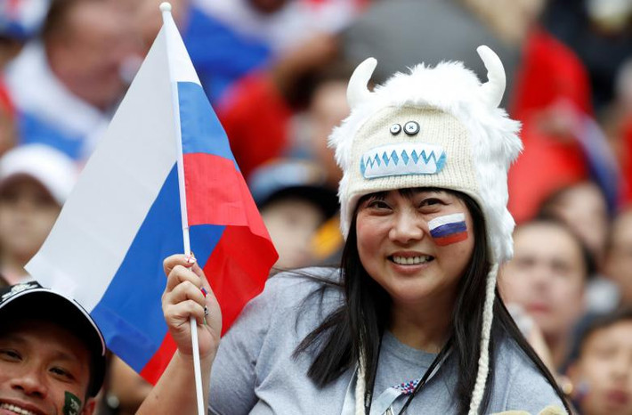 Một cổ động viên cầm theo cờ Nga trước khi trận khai mạc World Cup 2018 giữa đội tuyển Nga và Saudi Arabia bắt đầu. Ảnh: Reuters.
