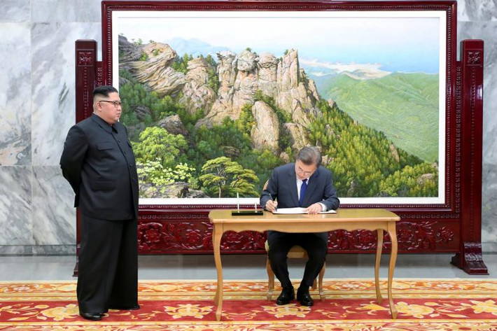 Tổng thống Moon viết vào sổ lưu niệm trước cuộc hội đàm với nhà lãnh đạo Kim Jong-un tại làng đình chiến Bàn Môn Điếm hôm 26/5. Ảnh: Reuters.