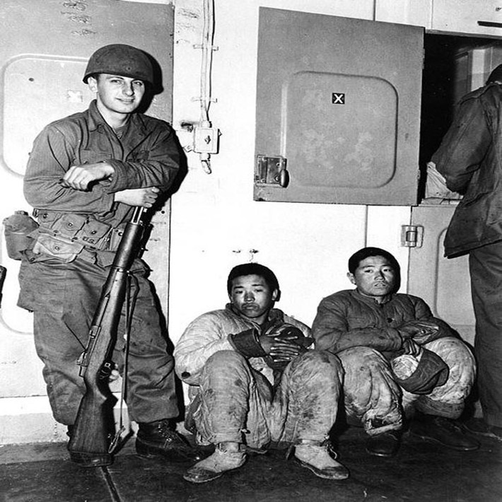 Lính thủy đánh bộ Mỹ canh gác hai “tù binh” khi áp giải họ từ Hungnam tới Pusan tháng 12/1950.