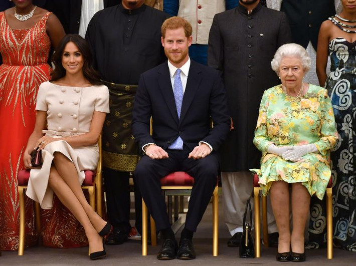 Từ phải sang: Nữ hoàng Anh Elizabeth II, Hoàng tử Harry và Công nương Markle trong một sự kiện tại Cung điện Buckingham ngày 26/6.