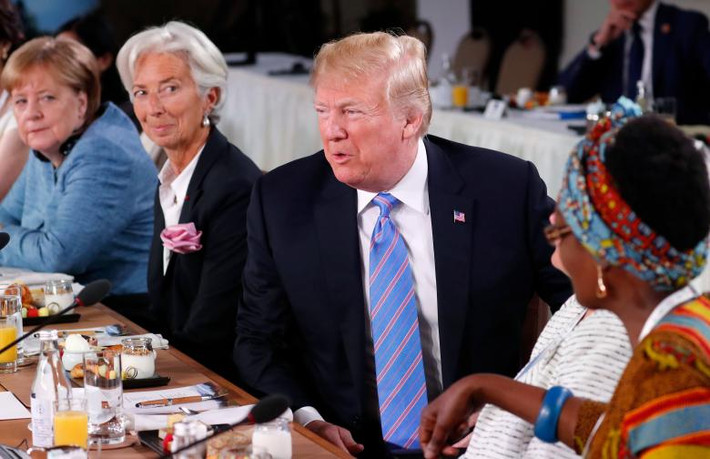 Tổng thống Trump trao đổi khi ngồi giữa Giám đốc Quỹ Tiền Tệ Quốc tế Christine Lagarde và nhà ngoại giao Uganda Winnie Byanima.