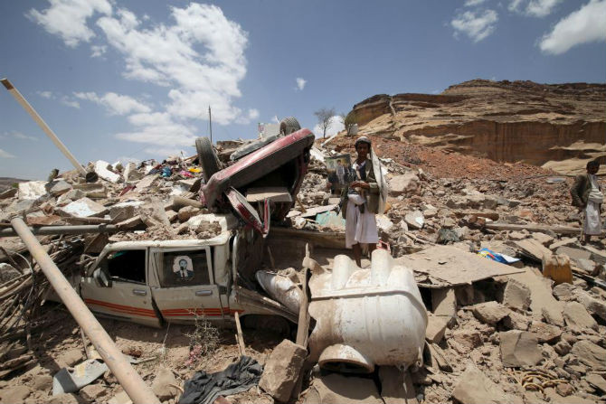 Ngôi nhà của thủ lĩnh Houthi Rafiq Rafiq chỉ còn là đống đổ nát sau cuộc tấn công của liên quân ngày 30/5. Một chiến binh Houthi đang cầm bức ảnh con trai của Rafiq. Cậu bé được cho là đã thiệt mạng trong cuộc không kích.