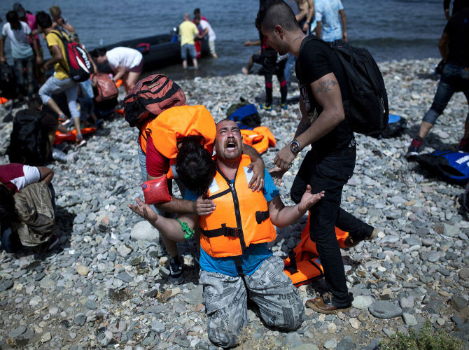 Một người tị nạn Syria cầu nguyện khi tới được đảo Lesbos, Hy Lạp, sau chuyến hành trình qua biển Aegean từ Thổ Nhĩ Kỳ ngày 7/9. Trong năm 2015, hơn 230 nghìn người đã đặt chân đến Hy Lạp và số người nhập cư tăng mạnh trong những tuần gần đây.