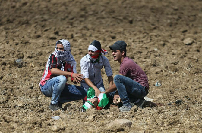 Một người biểu tình Palestine bị thương và nằm dưới đất trong cuộc đụng độ với binh sĩ Israel.
