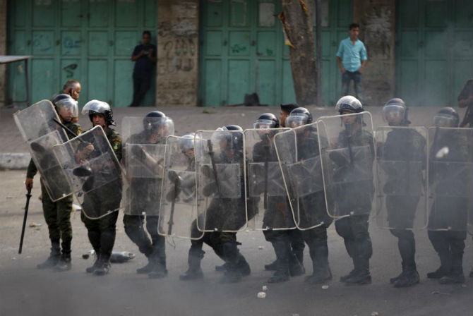 Lực lượng an ninh quốc gia Palestine cố ngăn những người biểu tình đến gần binh sĩ Israel.