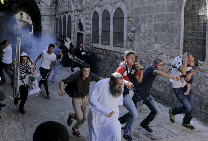 Người biểu tình Palestine bỏ chạy khi cảnh sát Israel ném lựu đạn gây choáng tại thành phố cổ Jerusalem ngày 28/9.