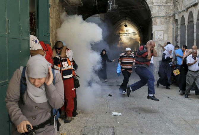 Những người biểu tình Palestine bỏ chạy khi cảnh sát Israel ném một quả lựu đạn gây choáng tại Jerusalem ngày 28/9.