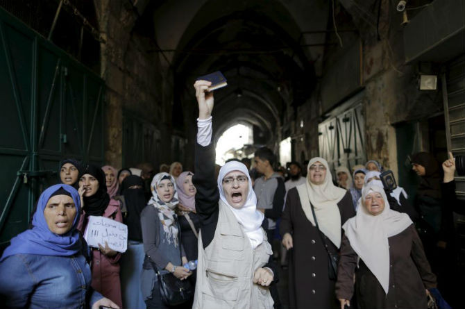 Một phụ nữ Palestine giơ cao cuốn kinh Koran và hô vang khẩu hiệu trong cuộc xung đột với cảnh sát Israel ngày 28/9.