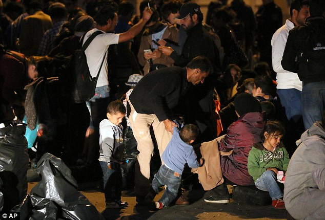 Hàng trăm di dân ngồi chờ xe buýt ở khu vực giữa biên giới Hungary và Áo.