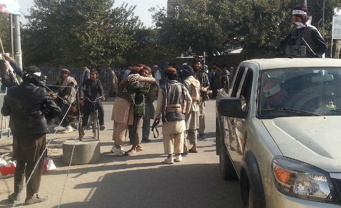 Các chiến binh Taliban ôm nhau vui mừng sau khi chiếm được thành phố chiến lược của Afghanistan.