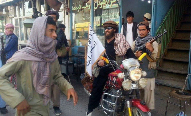 Một chiến binh Taliban ngồi trên chiếc xe máy treo cờ của nhóm này trên một con đường ở thành phố Kunduz ngày 29/9.