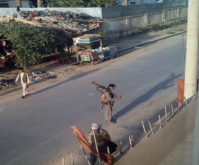 Chiến binh Taliban mang theo vũ khí đứng gác trên một con đường ở thành phố Kunduz ngày 28/9.