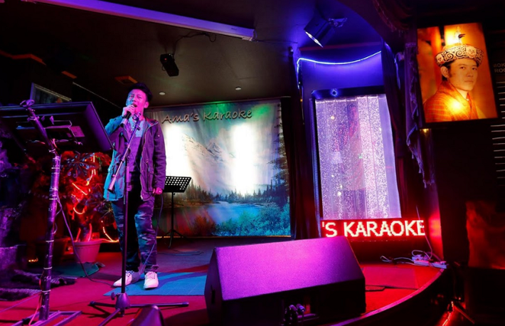 Người đàn ông say sưa hát trong quán Karaoke.