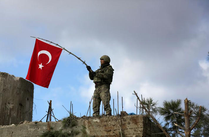 Một binh sĩ Thổ Nhĩ Kỳ vẫy cờ trên núi Barsaya, phía đông bắc Afrin, Syria. Ảnh: Reuters.