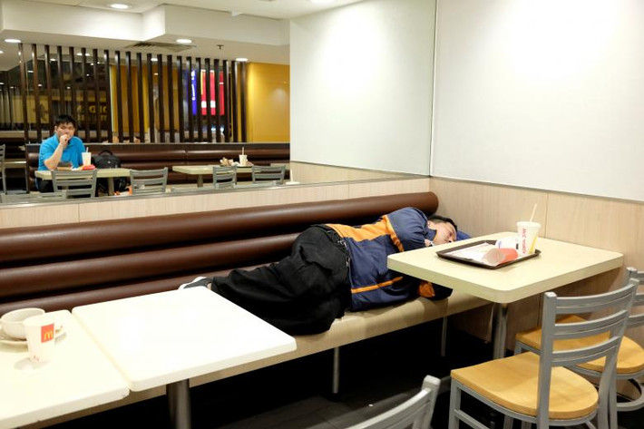 Một người đàn ông nằm ngủ trong nhà hàng McDonald ở quận Sham Shui Po lúc nửa đêm.