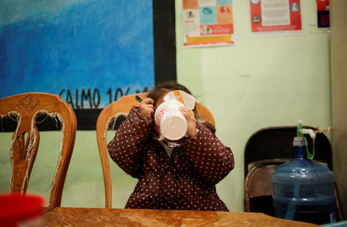 Bé gái di cư ngồi ăn trong trung tâm El Buen Samaritano ở Ciudad Juarez, ngày 21/3/2021.