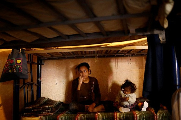 Sandra Soto, một người di cư đến từ Honduras, ngồi trên giường cùng con gái tại trung tâm El Buen Samaritano ở Ciudad Juarez, ngày 1/4.