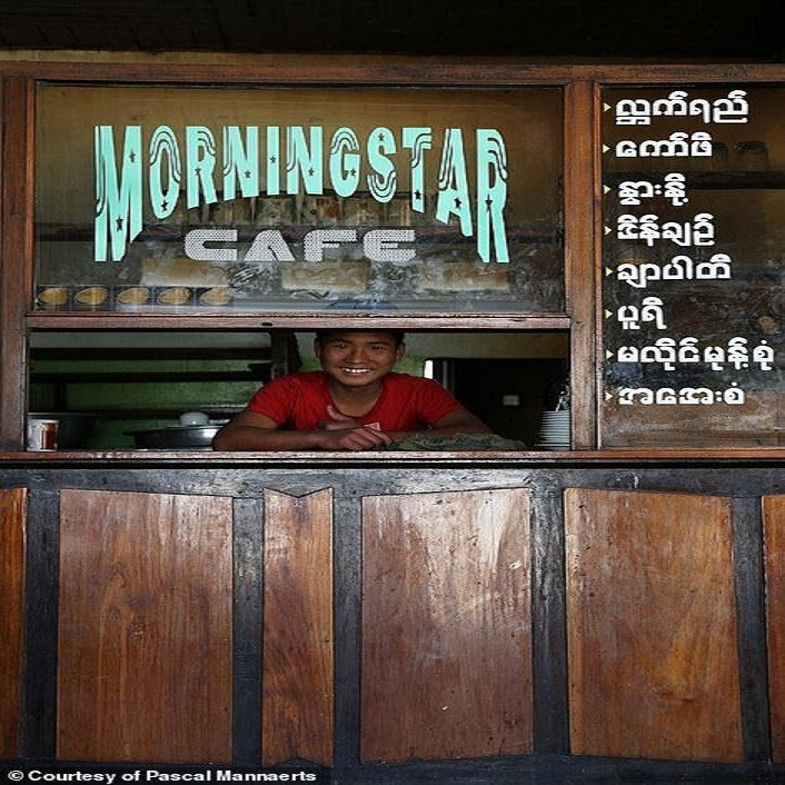 Bé trai cười tươi khi mở hàng bán cà phê ở Nyaung Shwe, Myanmar.