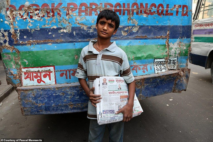 Một bé trai đi bán báo vào buổi sáng khắp đường phố Dhaka, Bangladesh.