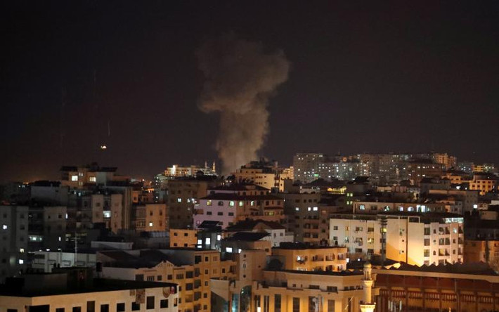 Khói bốc lên từ một tòa nhà ở Dải Gaza sau khi bị Israel không kích ngày 12/11. Ảnh: Reuters.