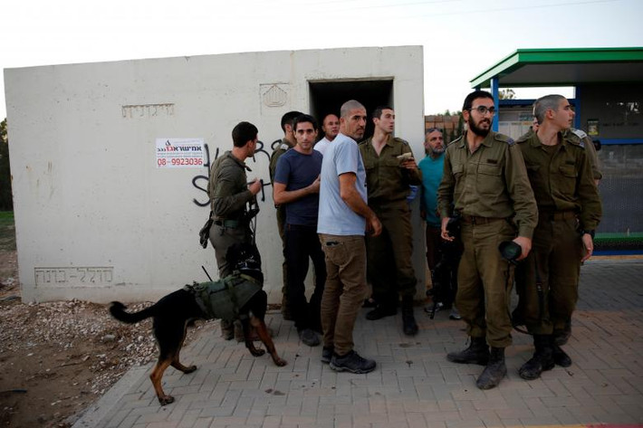 Các binh sĩ Israel và dân thường tập trung bên ngoài một hầm trú bom bên biên giới phía Israel. Ảnh: Reuters.