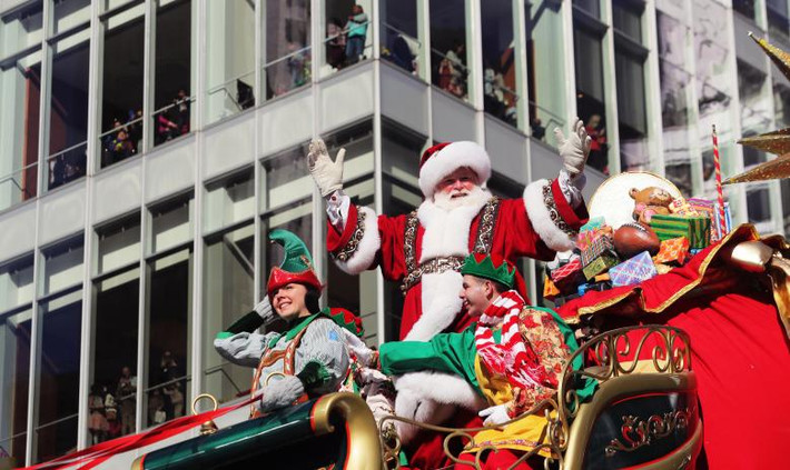 Người đàn ông mặc trang phục ông già Noel vẫy chào đám đông trên đường phố New York ngày 22/11. Ảnh: Reuters.