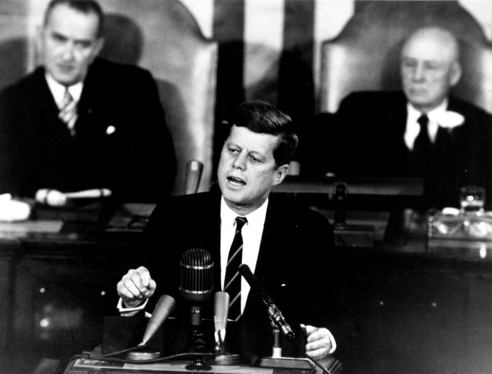 Tổng thống Kennedy phát biểu trước phiên họp chung của Quốc hội Mỹ ngày 25/5/1961. Phía sau ông là Phó Tổng thống Mỹ khi đó Lyndon Johnson (trái) và Chủ tịch Hạ viện Sam T. Rayburn.