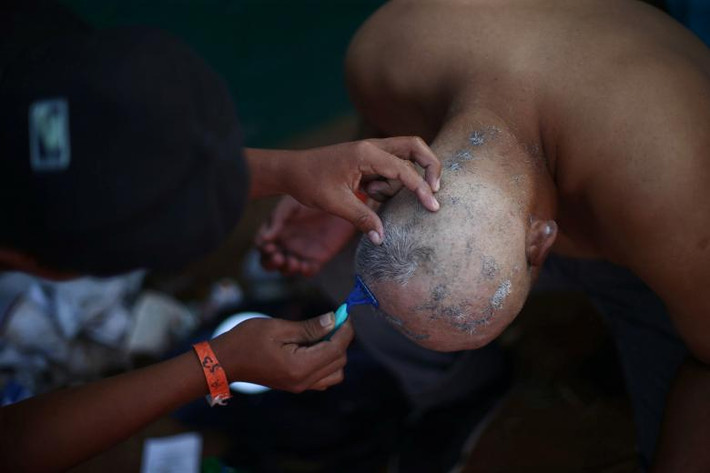 Rodolfo, 36 tuổi, cắt tóc trong khu trại tị nạn ở Tijuana.