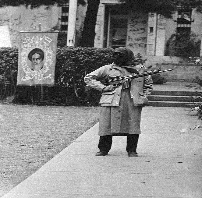 Một sinh viên Iran mang theo súng đứng canh gác bên ngoài Đại sứ quán Mỹ tại Tehran ngày 29/11/1979. Ảnh: Sputnik.
