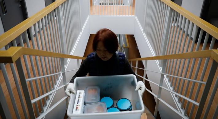 Một nhân viên của cơ sở Prison Inside Me mang đồ ăn cho các “tù nhân”.