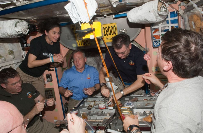 Các thành viên phi hành đoàn STS-133 và Trạm ISS ngồi ăn cùng nhau tại mô-đun Unity trên ISS.