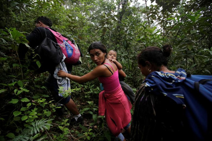 Các di dân Honduras băng qua một khu rừng sau khi vượt sông Lempa ở biên giới giữa Honduras và Guatemala ngày 17/10.