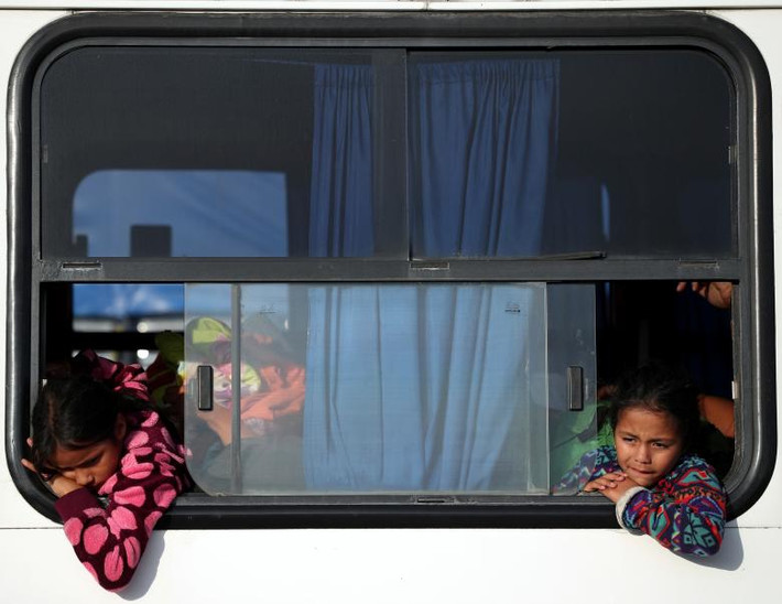 Bé Isis Alexandra, 8 tuổi, và Amanda Garcia, 6 tuổi, ngồi trên xe buýt tới Juchitan từ Santiago Niltipec, Mexico, ngày 30/10.