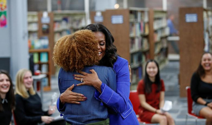 Bà Obama ôm một học sinh trong buổi giới thiệu cuốn tự truyện mới tại trường Whitney M. Young Magnet.