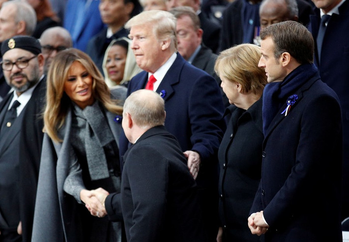 Tổng thống Putin bắt tay Đệ nhất phu nhân Mỹ Melania trong khi Tổng thống Trump đặt nhẹ tay lên lưng ông chủ Điện Kremlin tại sự kiện được tổ chức ở thủ đô Paris ngày 11/11. Ảnh: Reuters.