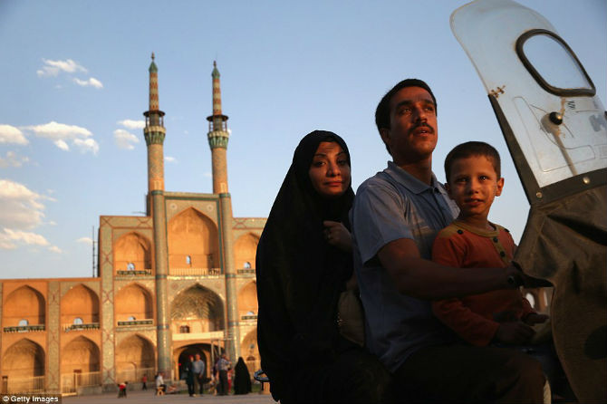 Một gia đình người Iran đi xe máy qua Amir Chakhmaq Hosseinieh, một trong những công trình lớn nhất tại quốc gia Hồi giáo này.
