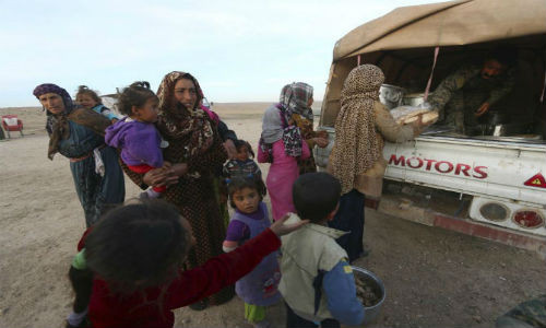 Các chiến binh SDF phân phát thực phẩm cho người dân Syria vừa chạy khỏi thị trấn Sabaa Zlam ở tỉnh Hasaka.