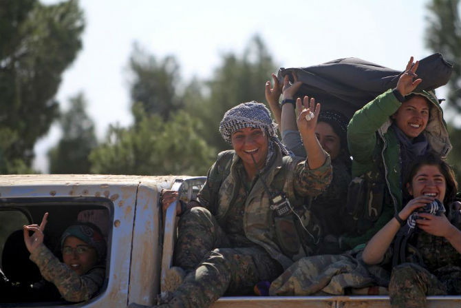 Nữ chiến binh SDF cười tươi khi đi qua khu vực gần thị trấn al-Shadadi, tỉnh Hasaka, Syria, ngày 18/2/2016.
