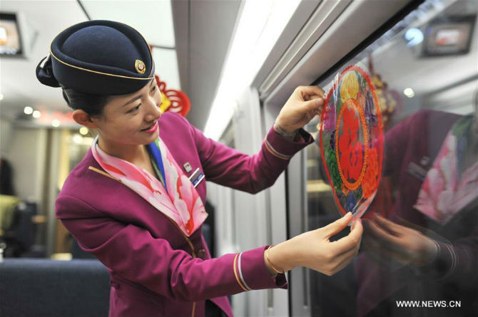 Nữ nhân viên trang trí cửa sổ cho con tàu trên chuyến tàu từ Thanh Đảo, tỉnh Sơn Đông, tới Bắc Kinh, ngày 30/1.