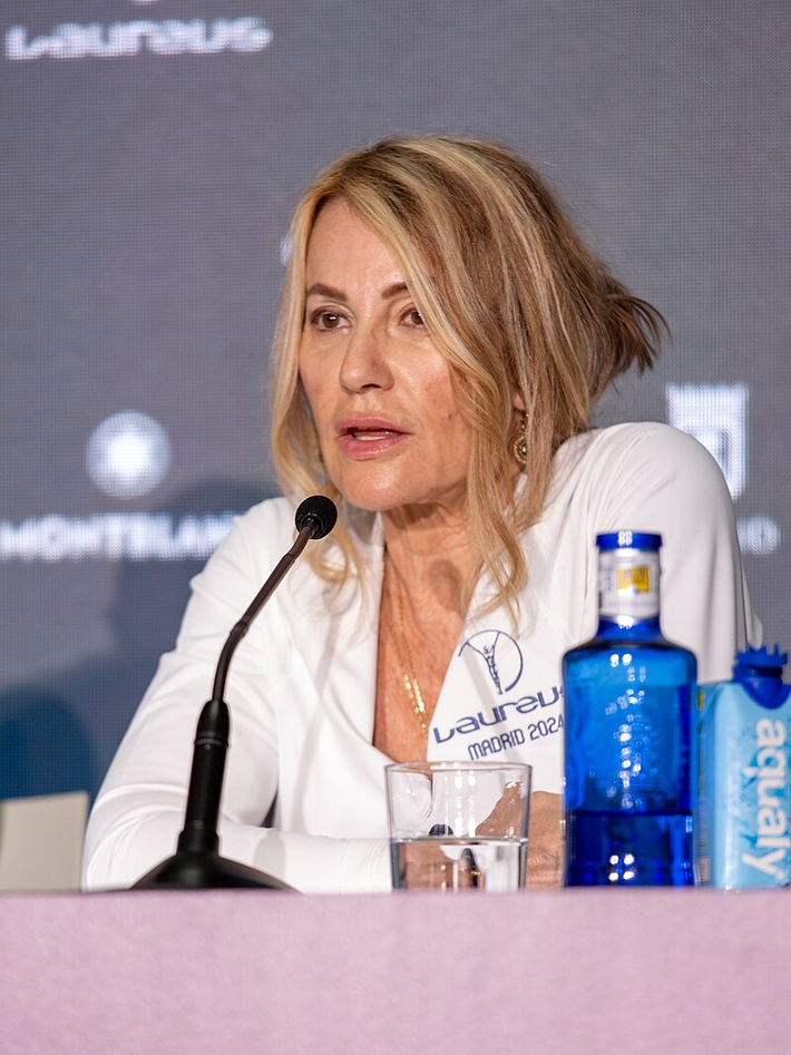 Vận động viên thể dục dụng cụ Olympic đầu tiên đạt điểm 10 tuyệt đối là Nadia Comaneci (vào năm 14 tuổi), người Romania. Trong ảnh là Nadia Comaneci năm 2024. Ảnh: Wikipedia.