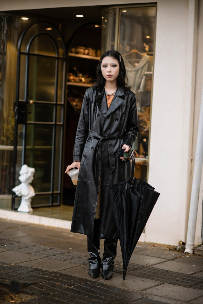 Lựa chọn set đồ gồm áo trench coat da cùng chiếc quần đơn giản nhưng cô nàng này vẫn trông vô cùng cá tính và ấn tượng. Chỉ cần diện một chiếc áo màu sắc nổi bật hơn một chút, kết hợp thêm vài món phụ kiện là đã có một combo thời trang khá hợp lí cho ngày mưa.