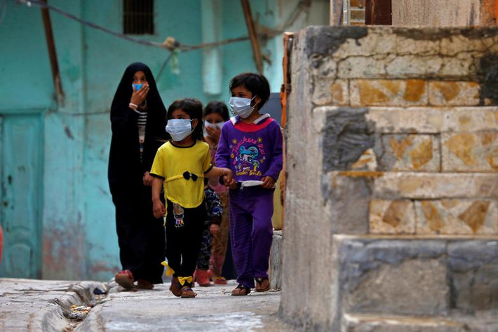 Các em nhỏ Iraq đeo khẩu trang gần một ngôi trường tôn giáo, nơi ca nhiễm virus corona đầu tiên ở nước này được phát hiện tại thành phố Najaf ngày 24/2.