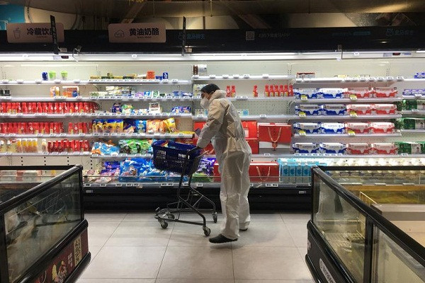 Khách hàng mặc đồ bảo hộ cẩn thận trong một siêu thị ở "tâm dịch" Covid-19 hôm 11/2.