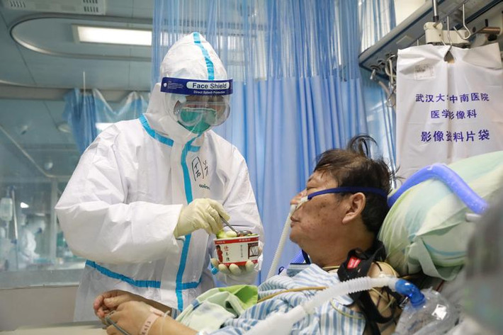 Y tá bón đồ ăn cho một bệnh nhân nhiễm virus corona đang được điều trị trong phòng cách ly tại Bệnh viện Zhongnan thuộc Đại học Vũ Hán ngày 8/2.