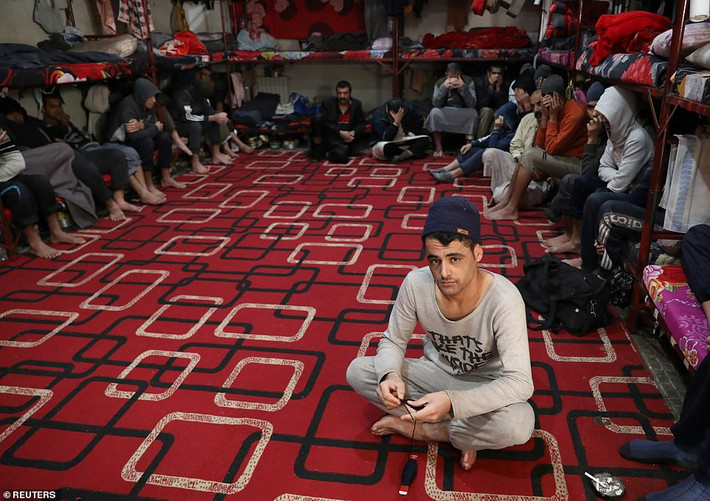 Những tù binh đến từ Iraq và Syria ngồi trong một phòng giam ở Hasaka.