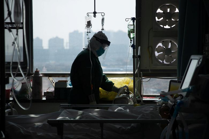 Một nhân viên y tế mặc đồ bảo hộ kiểm tra sức khỏe bệnh nhân nhiễm virus corona trong phòng cách ly tại một bệnh viện của thành phố Vũ Hán hôm 22/2.